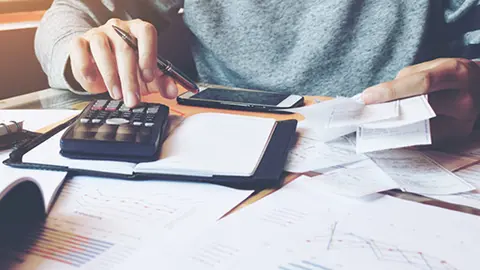 Man using calculator and calculate bills in home office.