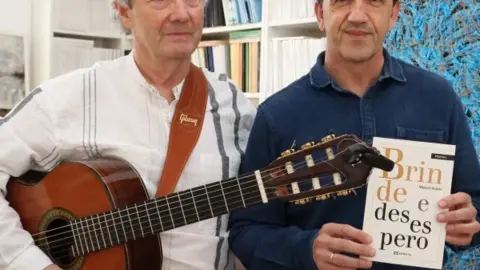 Miguel Sande e o cantautor Cesar Mor&aacute;n, co libro de poemas "Brinde e desespero".